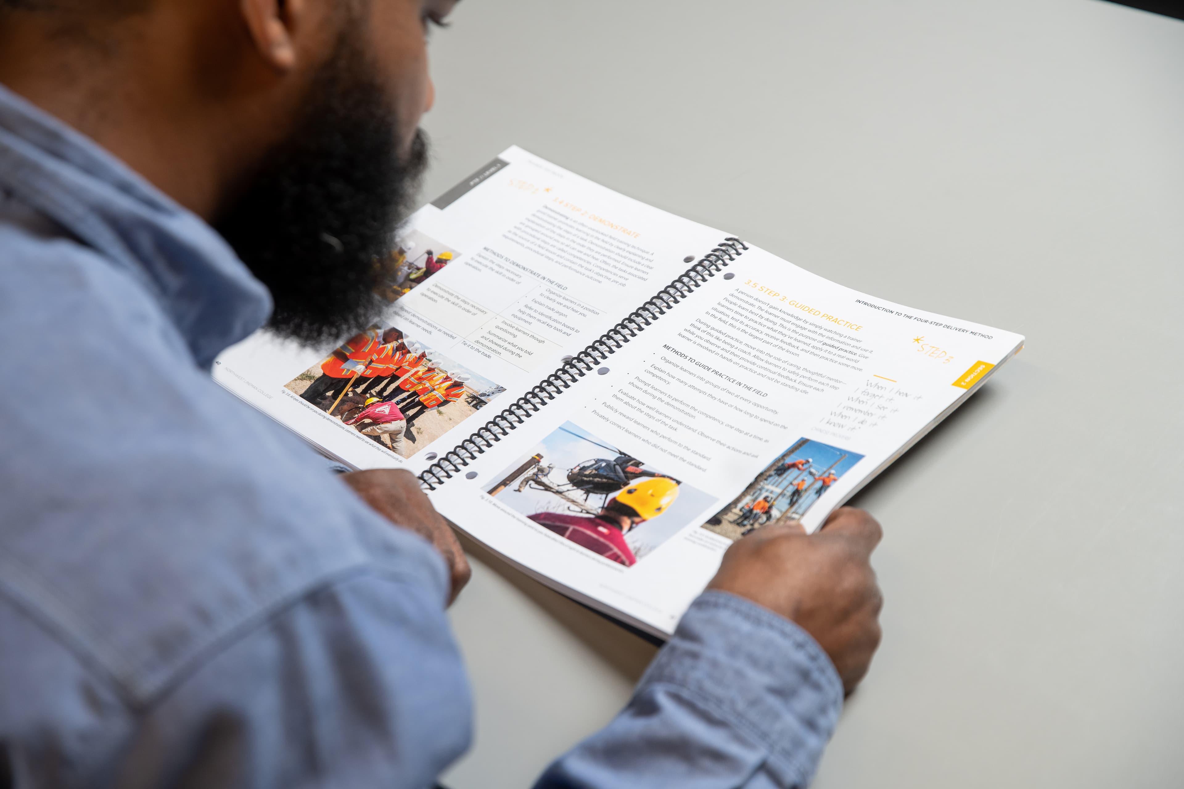 man looking at NLC curriculum while seated at a desk