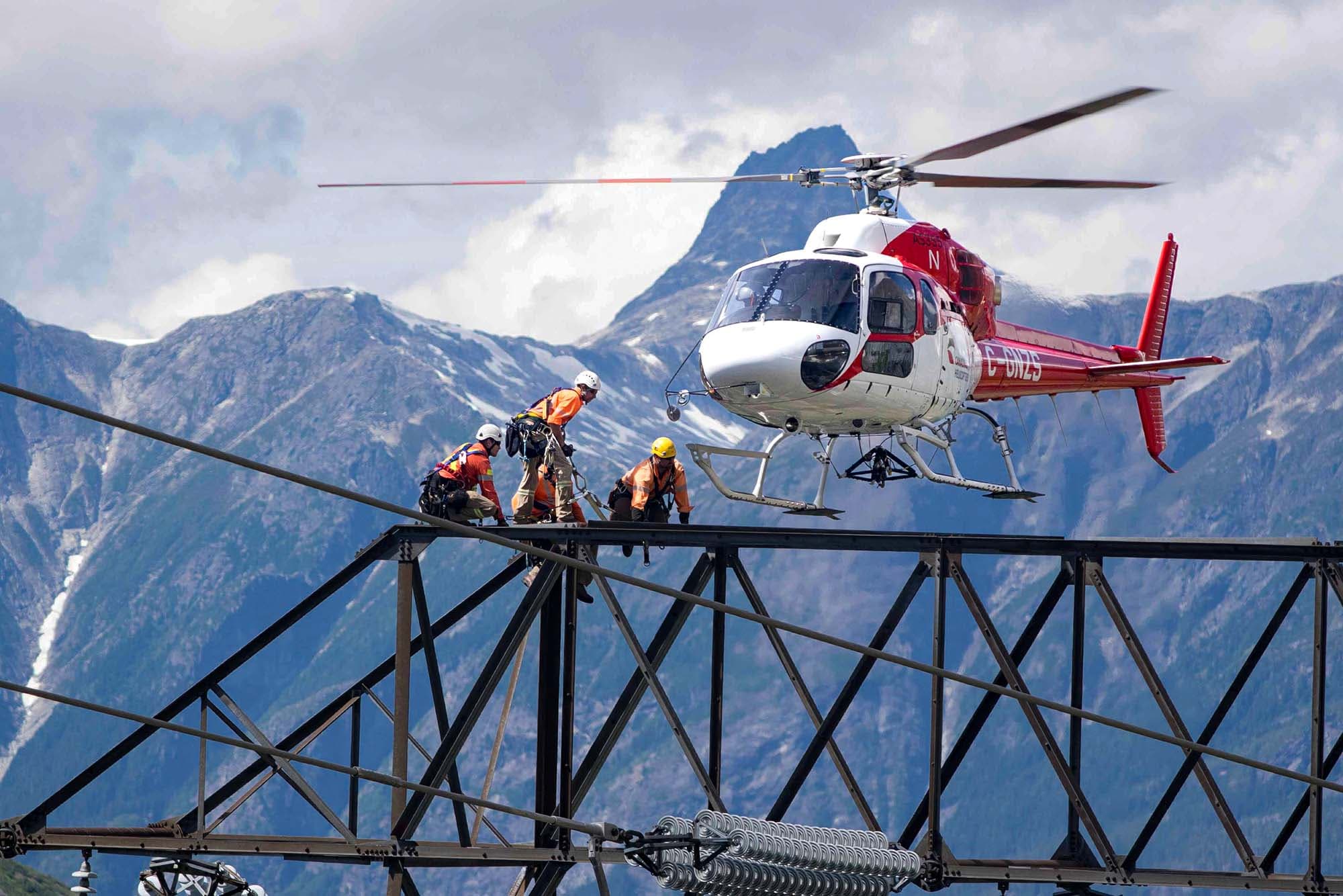 Helicopter lands on tower with lineman.