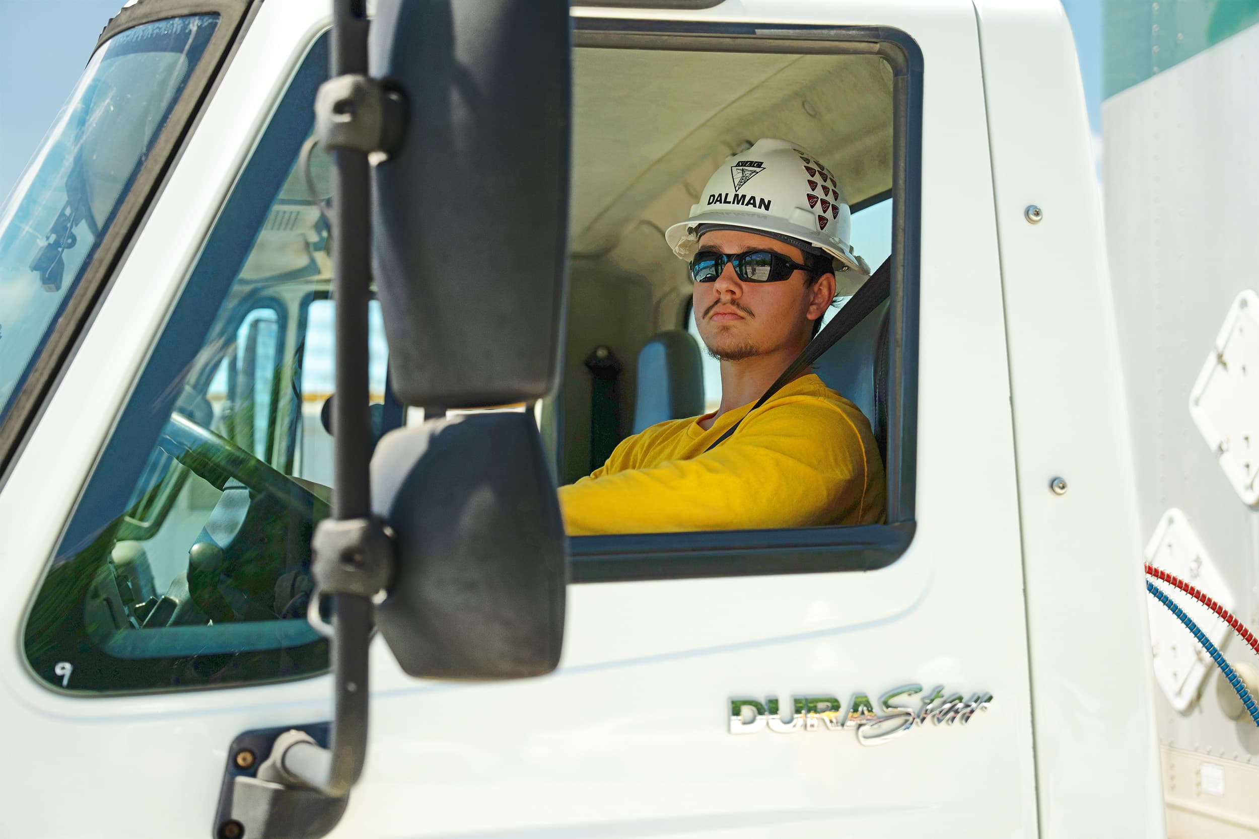 NLC student in drivers seat of truck, looking out the drivers window