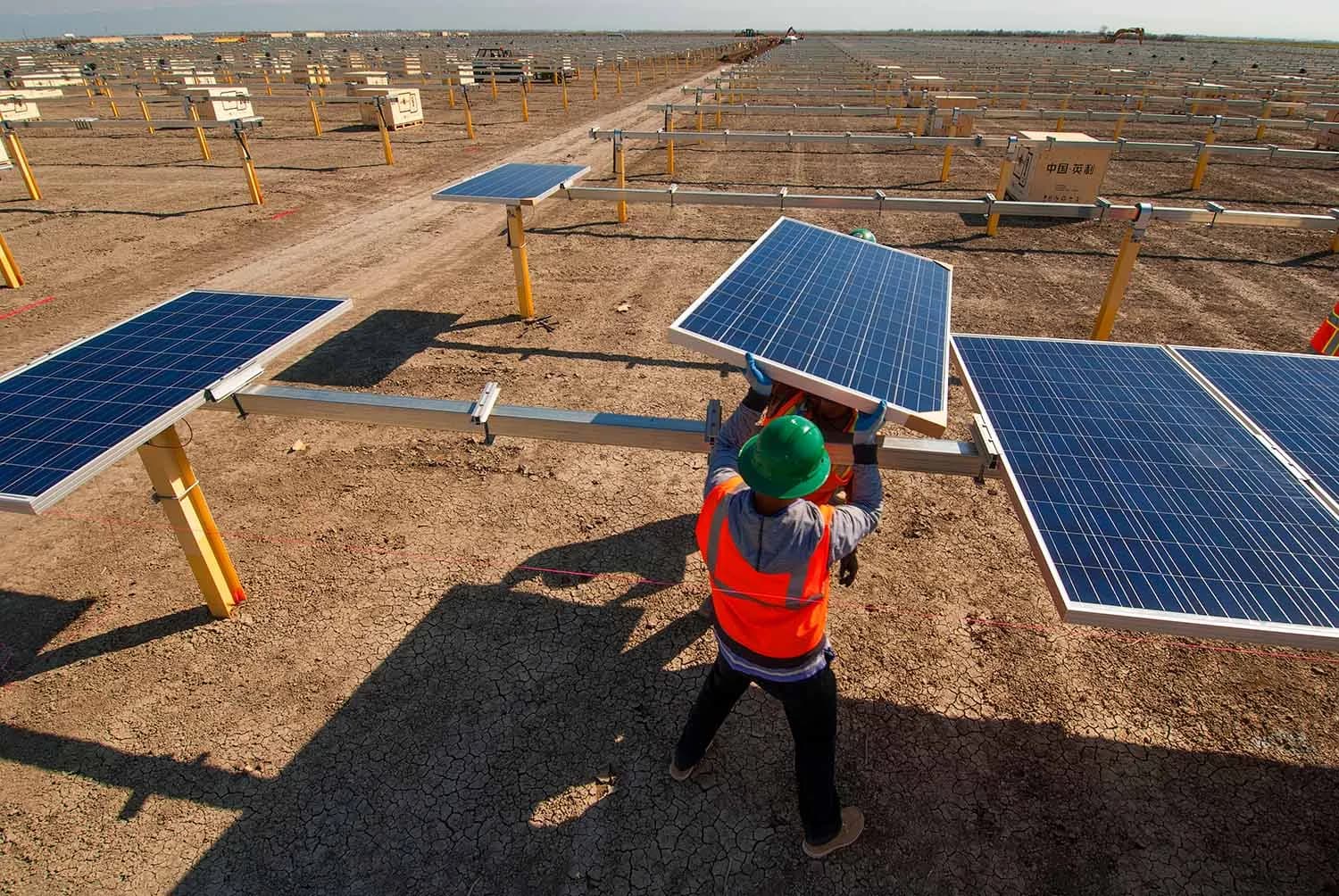 Workers lifting solar panel into position.