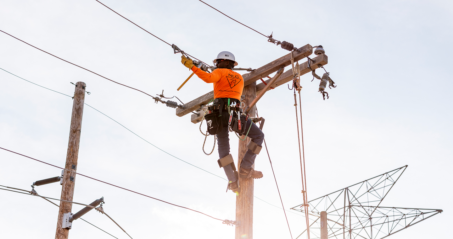 Lineman working a power line on a power pole | Northwest Lineman College